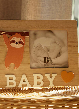 A charming wooden baby photo frame featuring an adorable sloth design, perfect for displaying cherished baby photos. This whimsical frame is an ideal home decor piece for any nursery or living room, making it a thoughtful gift for new parents or families with babies. With its cute sloth illustration and durable wooden construction, it adds a playful touch to any room while preserving precious memories. This baby photo frame makes a wonderful gift for baby showers or any special occasion, combining functiona