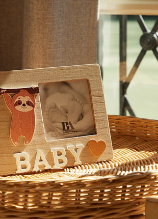 A charming wooden baby photo frame featuring an adorable sloth design, perfect for displaying cherished baby photos. This whimsical frame is an ideal home decor piece for any nursery or living room, making it a thoughtful gift for new parents or families with babies. With its cute sloth illustration and durable wooden construction, it adds a playful touch to any room while preserving precious memories. This baby photo frame makes a wonderful gift for baby showers or any special occasion, combining functiona