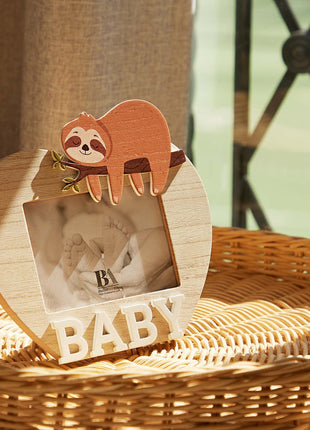 A charming wooden baby photo frame featuring an adorable sloth design, perfect for displaying cherished baby photos. This whimsical frame is an ideal home decor piece for any nursery or living room, making it a thoughtful gift for new parents or families with babies. With its cute sloth illustration and durable wooden construction, it adds a playful touch to any room while preserving precious memories. This baby photo frame makes a wonderful gift for baby showers or any special occasion, combining functiona
