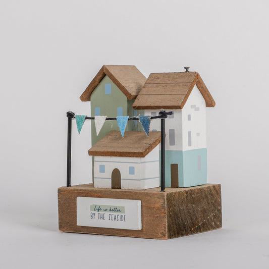 Charming coastal cottage miniature house decor in a beautiful seaside style, Life is Better by the Seaside, featuring a blue color scheme and intricate wooden design. This elegant home ornament adds a coastal vibe to any space, perfect for living rooms, offices, or as a gift for beach lovers. 1

