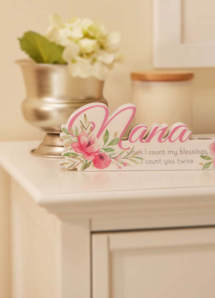 A charming floral vase featuring the word "Nana" in beautiful lettering, surrounded by vibrant flowers. This elegant home decor piece is designed as a thoughtful gift for grandma, perfect for birthdays, holidays, or any special occasion. The floral details and personalized "Nana" text make it a meaningful and heartfelt present, adding warmth and beauty to her home. Ideal for showing love and appreciation, this vase serves as both a decorative ornament and a lasting reminder of your special bond with your gr