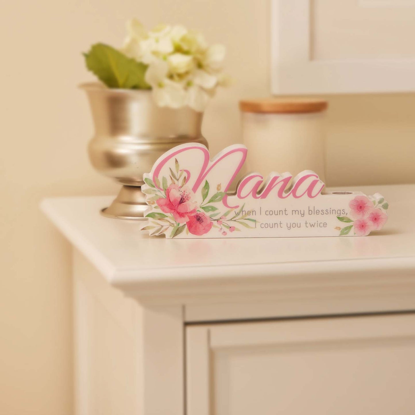 A charming floral vase featuring the word "Nana" in beautiful lettering, surrounded by vibrant flowers. This elegant home decor piece is designed as a thoughtful gift for grandma, perfect for birthdays, holidays, or any special occasion. The floral details and personalized "Nana" text make it a meaningful and heartfelt present, adding warmth and beauty to her home. Ideal for showing love and appreciation, this vase serves as both a decorative ornament and a lasting reminder of your special bond with your gr