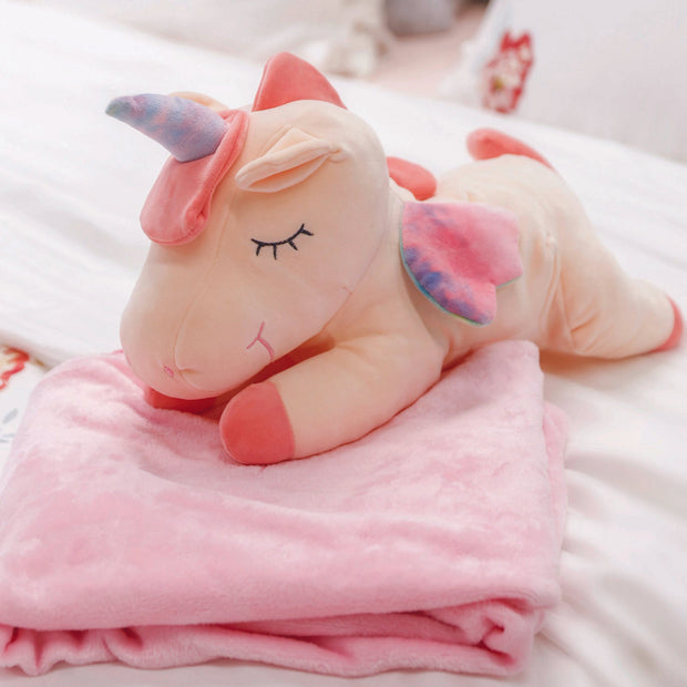 Adorable pink unicorn plush toy with rainbow wings, featuring a cozy unicorn blanket tucked inside its belly. Soft and cuddly, this squishmallow-style stuffed animal doubles as a pillow for kids, making it the perfect plushie and comfort companion for bedtime or playtime. 3
