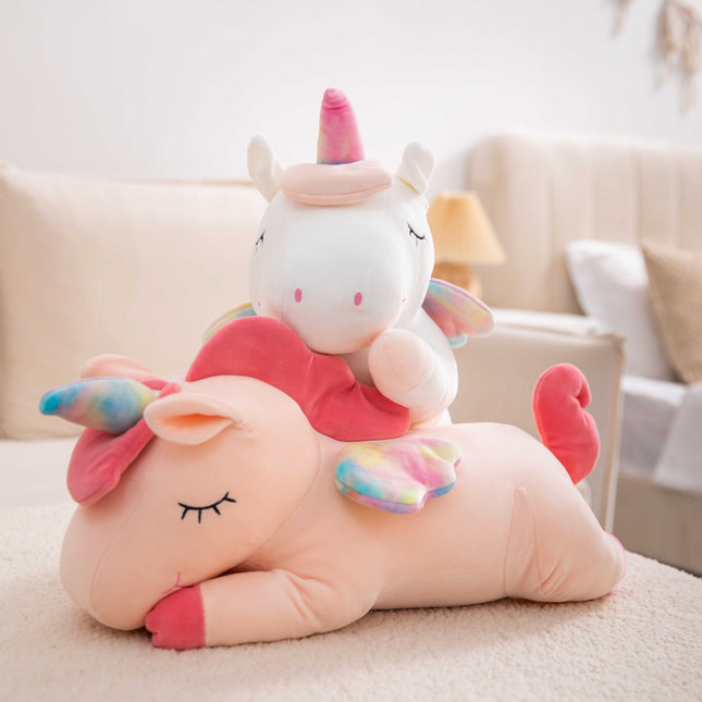 Adorable pink unicorn plush toy with rainbow wings, featuring a cozy unicorn blanket tucked inside its belly. Soft and cuddly, this squishmallow-style stuffed animal doubles as a pillow for kids, making it the perfect plushie and comfort companion for bedtime or playtime. 4
