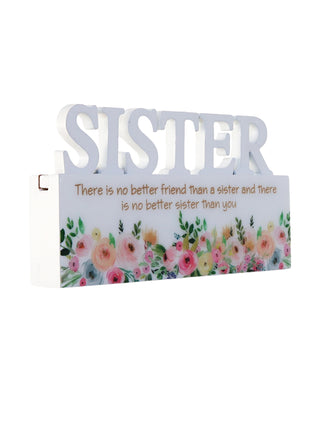 A charming white decorative ornament featuring the word "Sister" with beautiful floral patterns, making it an ideal home decor gift for your sister. The delicate floral design adds a touch of elegance and warmth, making it a perfect gift for birthdays, holidays, or any special occasion. This meaningful ornament symbolizes the love and connection shared between siblings and serves as a reminder of cherished moments. The simple yet elegant white color complements any home decor style, creating a heartfelt and
