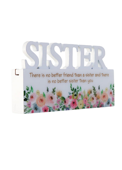 A charming white decorative ornament featuring the word "Sister" with beautiful floral patterns, making it an ideal home decor gift for your sister. The delicate floral design adds a touch of elegance and warmth, making it a perfect gift for birthdays, holidays, or any special occasion. This meaningful ornament symbolizes the love and connection shared between siblings and serves as a reminder of cherished moments. The simple yet elegant white color complements any home decor style, creating a heartfelt and