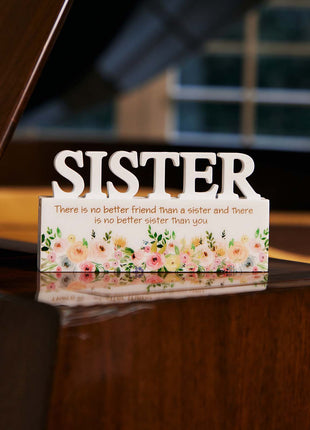 A charming white decorative ornament featuring the word "Sister" with beautiful floral patterns, making it an ideal home decor gift for your sister. The delicate floral design adds a touch of elegance and warmth, making it a perfect gift for birthdays, holidays, or any special occasion. This meaningful ornament symbolizes the love and connection shared between siblings and serves as a reminder of cherished moments. The simple yet elegant white color complements any home decor style, creating a heartfelt and