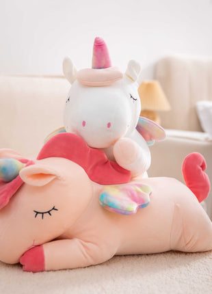 Adorable white unicorn plush toy with rainbow wings, featuring a cozy unicorn blanket tucked inside its belly. Soft and cuddly, this squishmallow-style stuffed animal doubles as a pillow for kids, making it the perfect plushie and comfort companion for bedtime or playtime. 4
